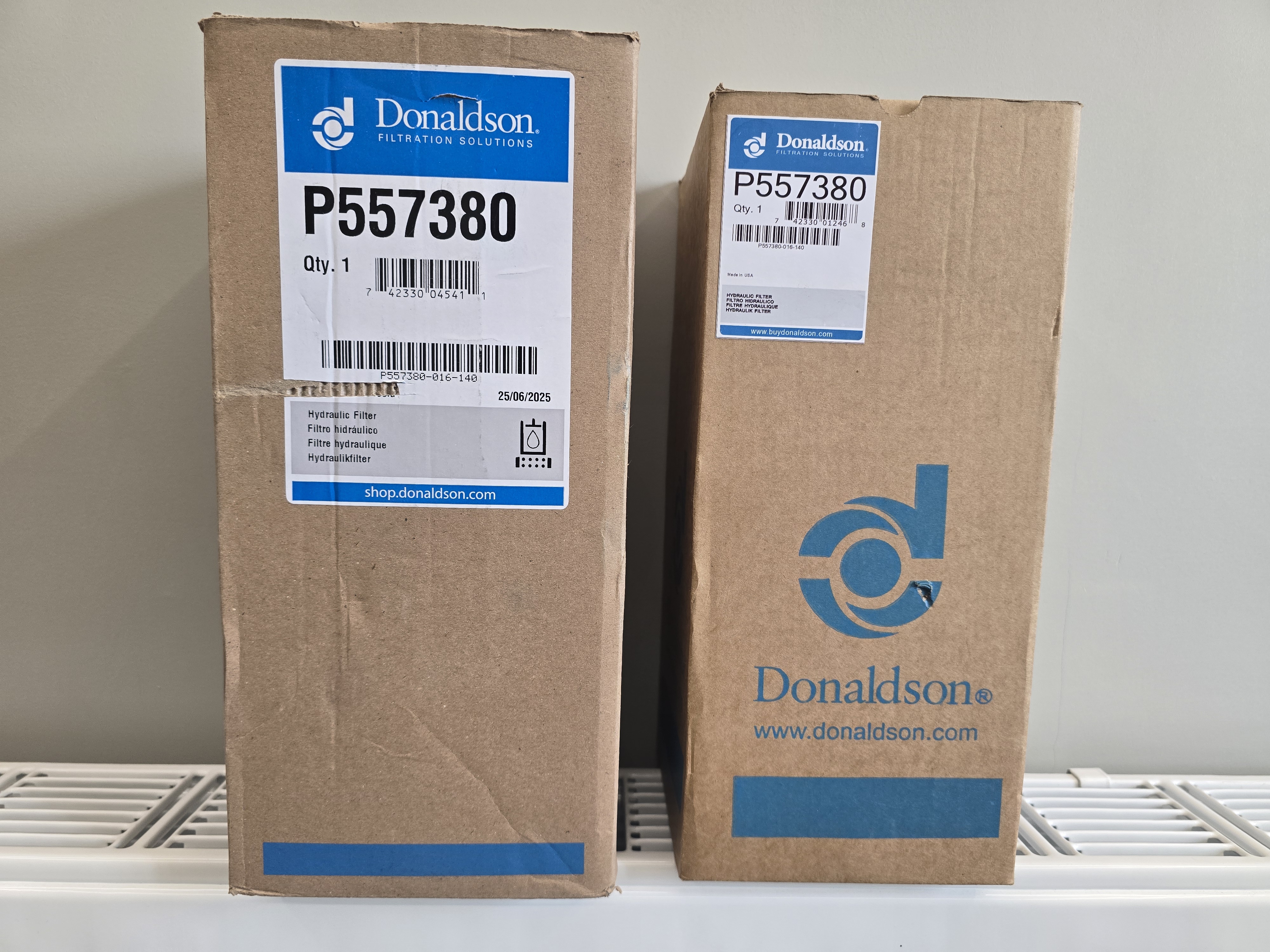 Сравнение двух коробок фильтра Donaldson P557380: оригинальная слева и поддельная справа